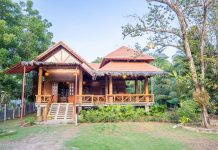 บ้านไม้ยกพื้นหรูหรา มีระเบียงด้านหน้ากว้าง ใต้ถุนบ้านทำเป็นที่จอดรถ